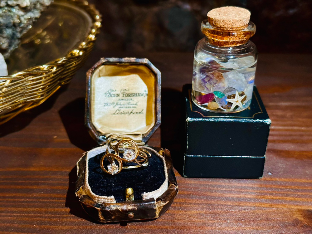 西洋骨董の雰囲気がある机の上に、小ぶりなジュエリーケース。鈍く光る金色のリングが収まっている。