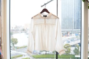 明るく爽やかな横浜の湾岸風景、白いブラウスが１枚、ハンガーに吊るされている。