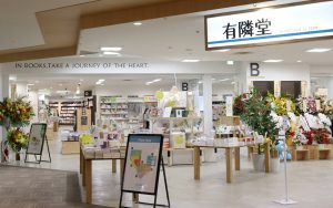 ニッケコルトンプラザ通路から見た入口フェアコーナーの奥に書棚が並んでいる