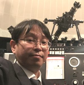 プラネタリウム投影機と先生の近影