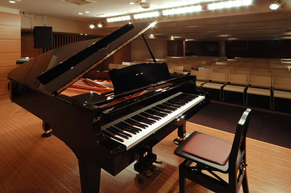 会場ホールのイメージ。ステージにグランドピアノがあり、広い会場に椅子が並んでいるコンサート用の状態