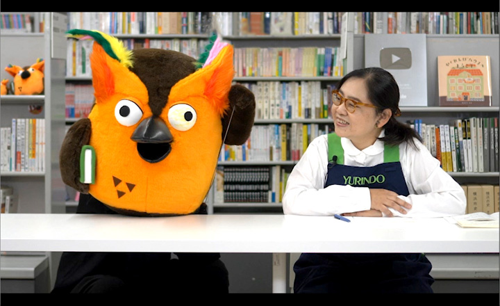 チャンネルのイメージ。文房具バイヤー岡﨑とブッコローが撮影スタジオで横並びに座っている