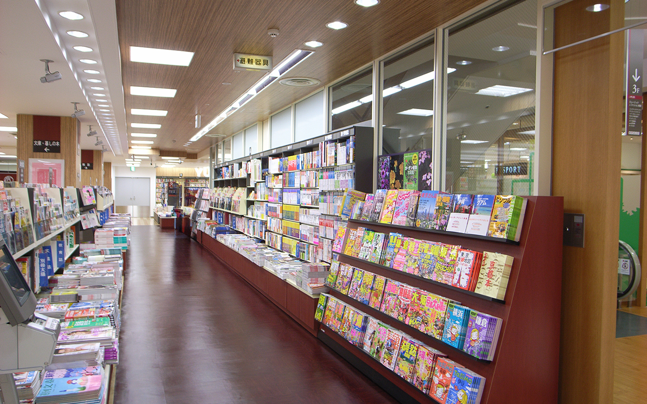 ビル通路の両側に雑誌・ガイドブックの棚