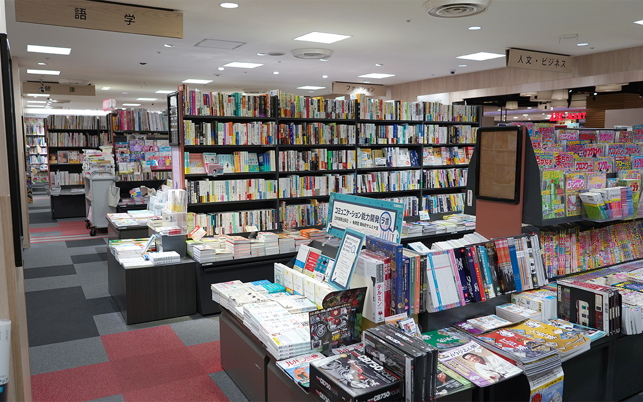 雑誌売場・書籍売場。カーペット敷きの店内に背の低い書棚