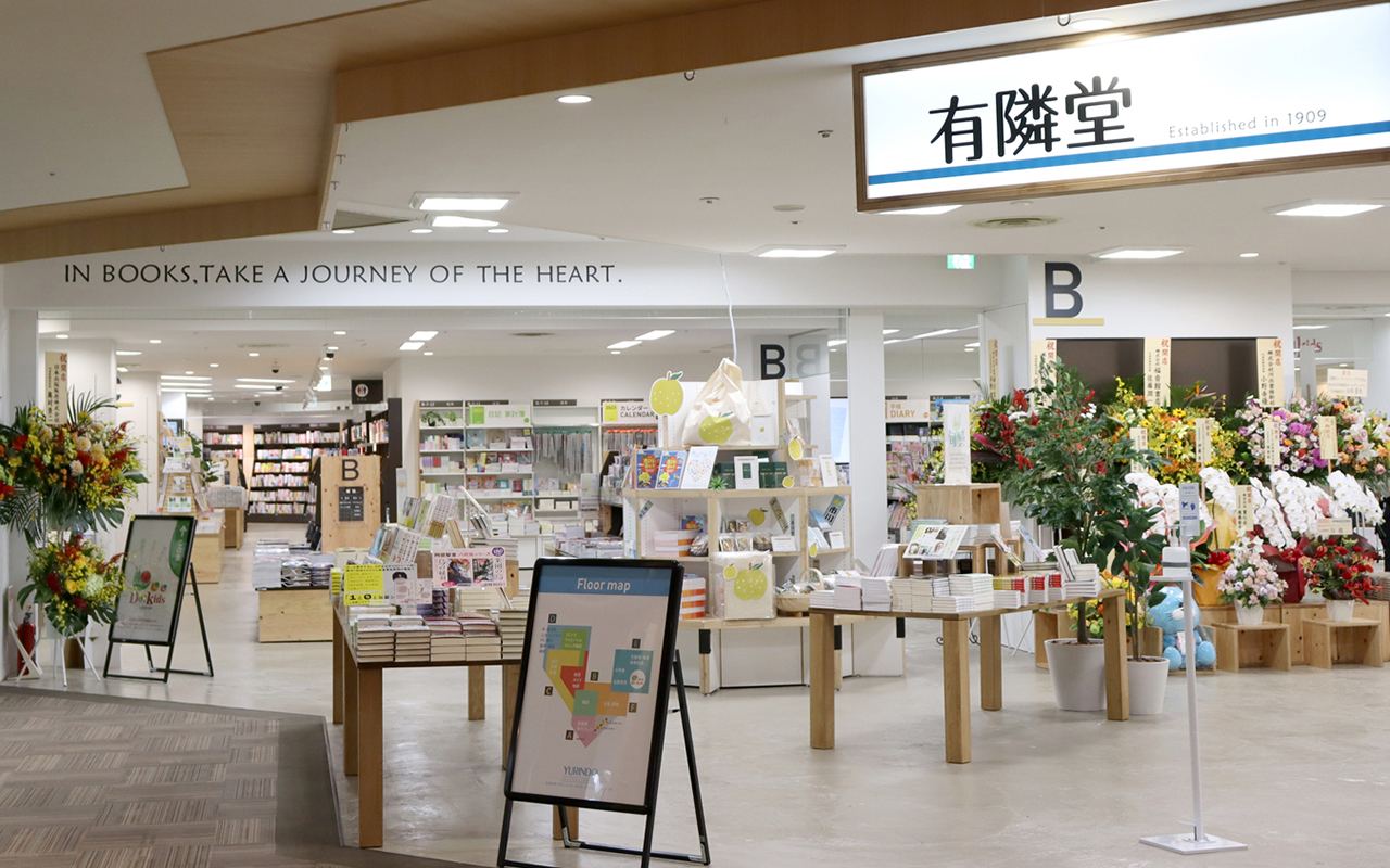 ニッケコルトンプラザ通路から見た入口フェアコーナーの奥に書棚が並んでいる