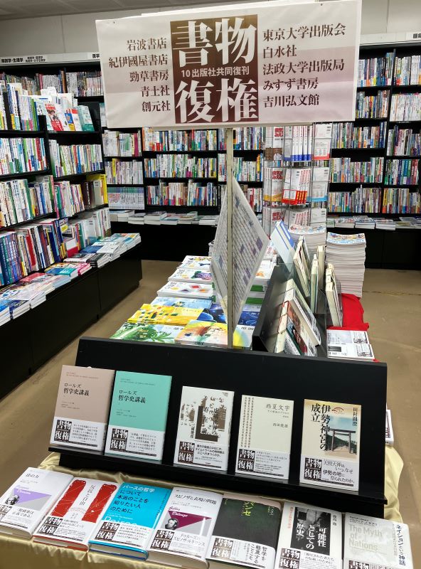 書籍売場に「書物復権」と書かれた看板、ハードカバーの本が表紙を表に向けて並べられている